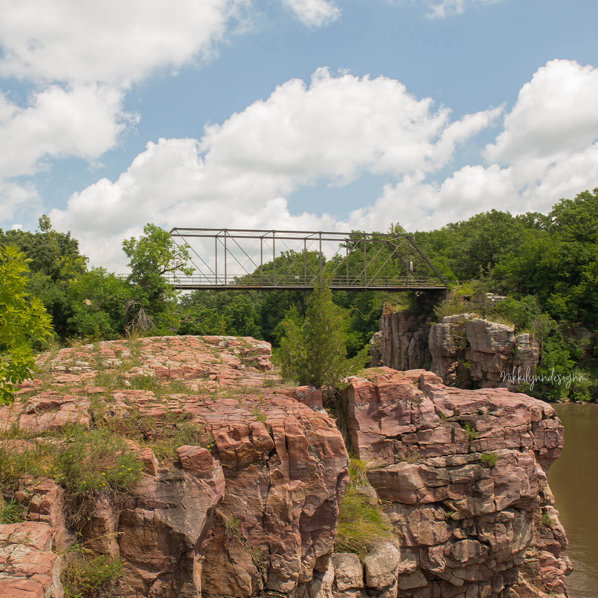 Historic truss bridge crossing pink Sioux quartzite cliffs at Palisades State Park near Garretson, South Dakota.