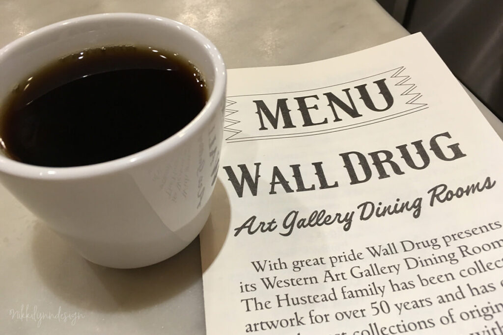 Cup of coffee on a table beside the Wall Drug dining room menu in Wall South Dakota