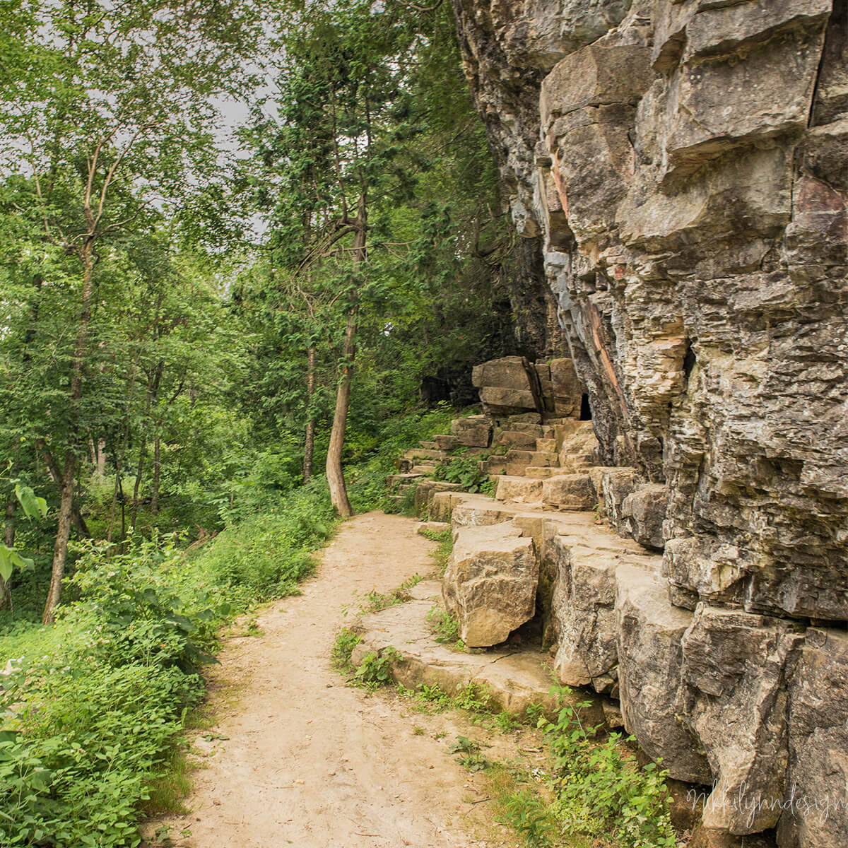 Rocky trail and dolomite cliff at Cherney Maribel Caves County Park in Manitowoc County Wisconsin