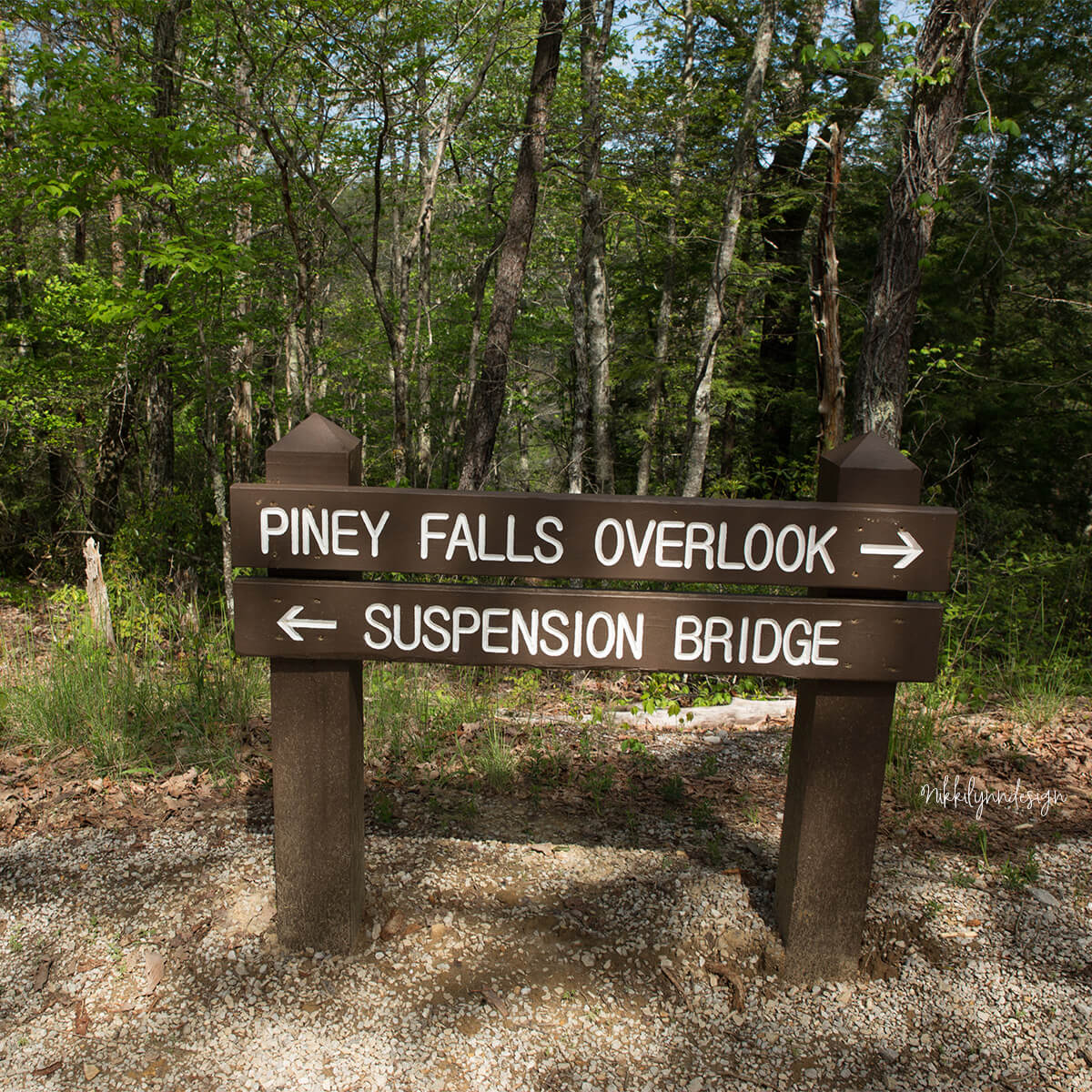 Trail sign at Piney Falls State Natural Area in Grandview Tennessee pointing to Piney Falls overlook and suspension bridge.