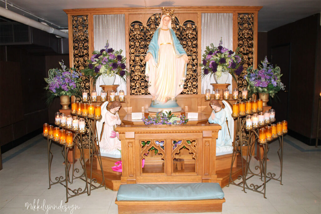 Statue of the Virgin Mary surrounded by prayer candles inside the Shrine of Our Lady of Good Help chapel in Champion Wisconsin