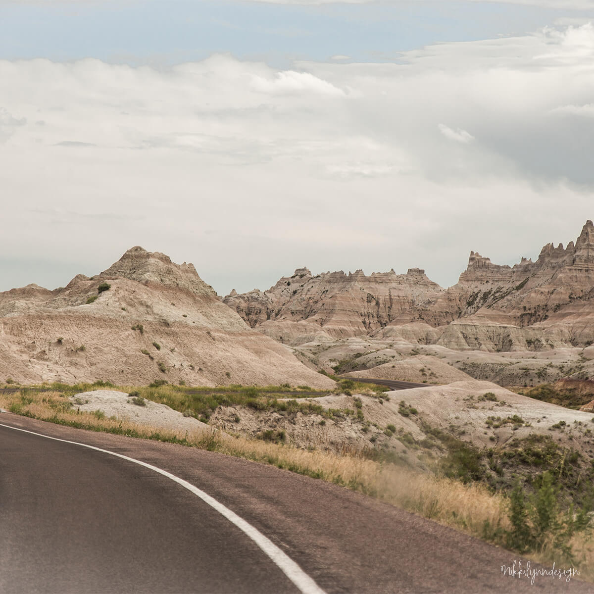 Road entering the Pinnacles Entrance of Badlands National Park with layered rock formations in South Dakota.