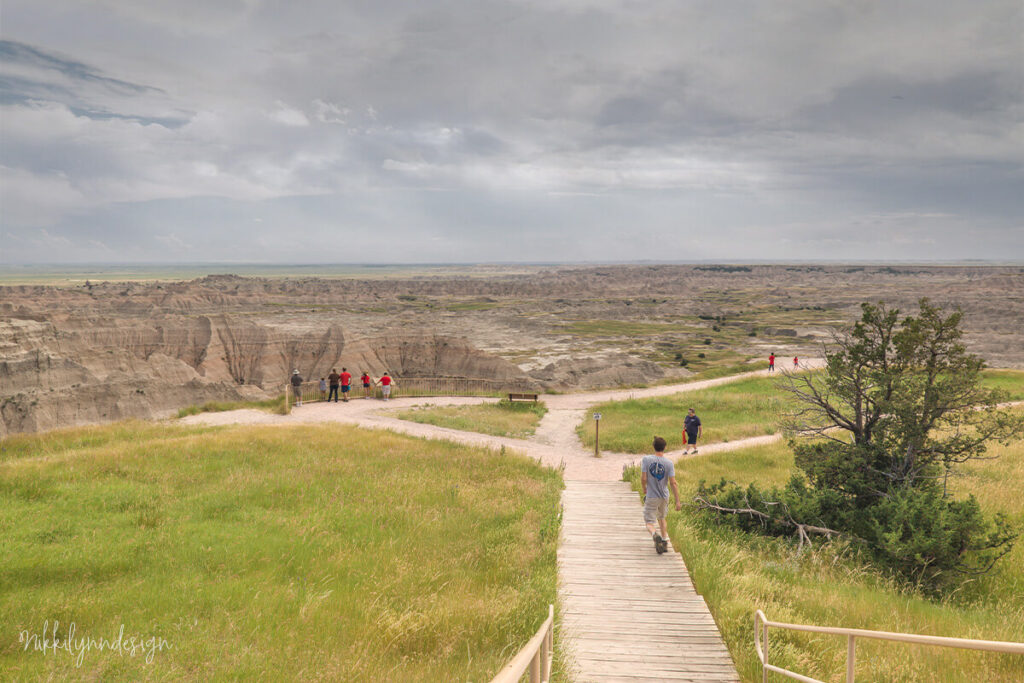 Visitors walking along a scenic overlook boardwalk in Badlands National Park South Dakota