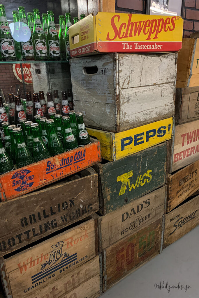 Collection of vintage soda crates including Pepsi and Schweppes beverage crates